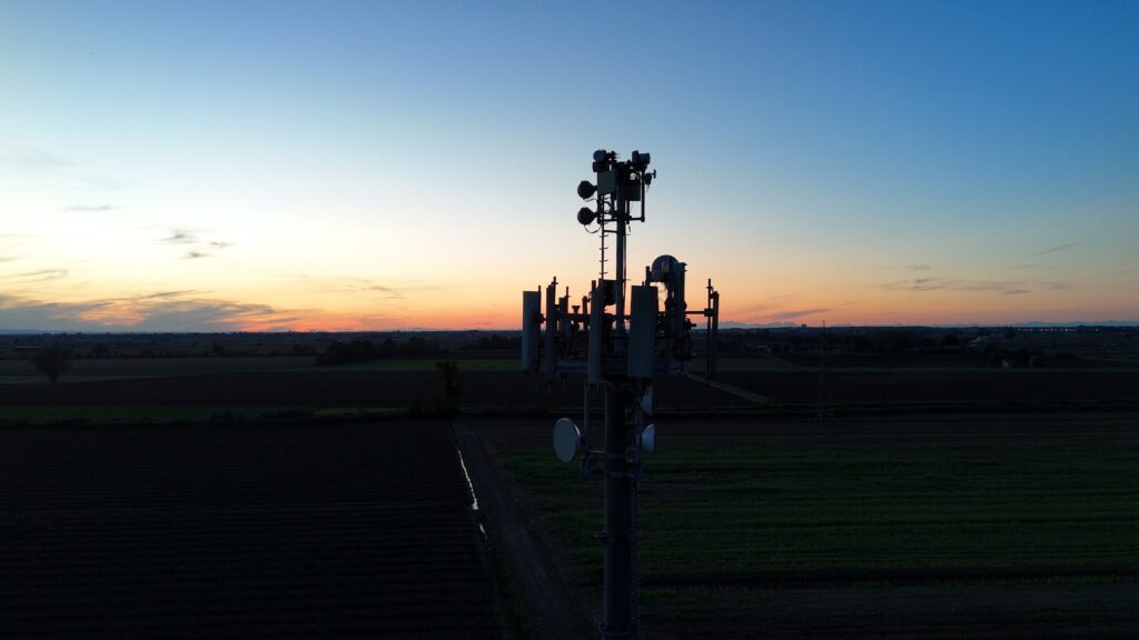 Cell tower on farmland at sunset